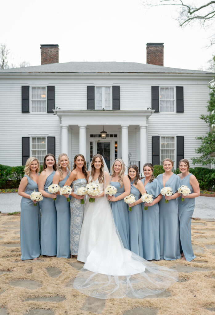 A bride and her bridesmaids in dusty blue dresses at Primrose Cottage in Roswell, Georgia