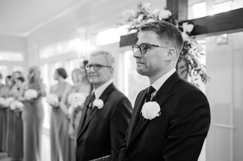 A groom watching his bride walk down the aisle on their wedding day at Primrose Cottage in Roswell Georgia