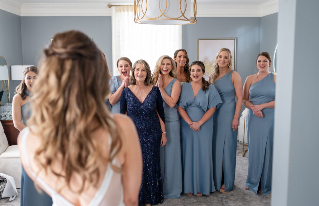 A bride doing a first look reveal with her bridesmaid and family on her wedding day at Primrose Cottage in Roswell, Georgia